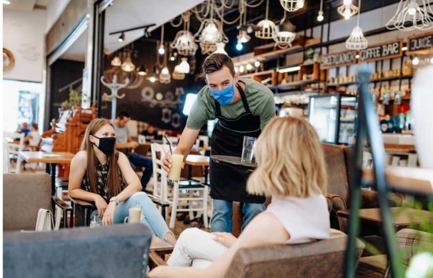 Waiter serving two people in the bar area - 4 Eye-Opening Benefits of Graphic Design for Restaurants