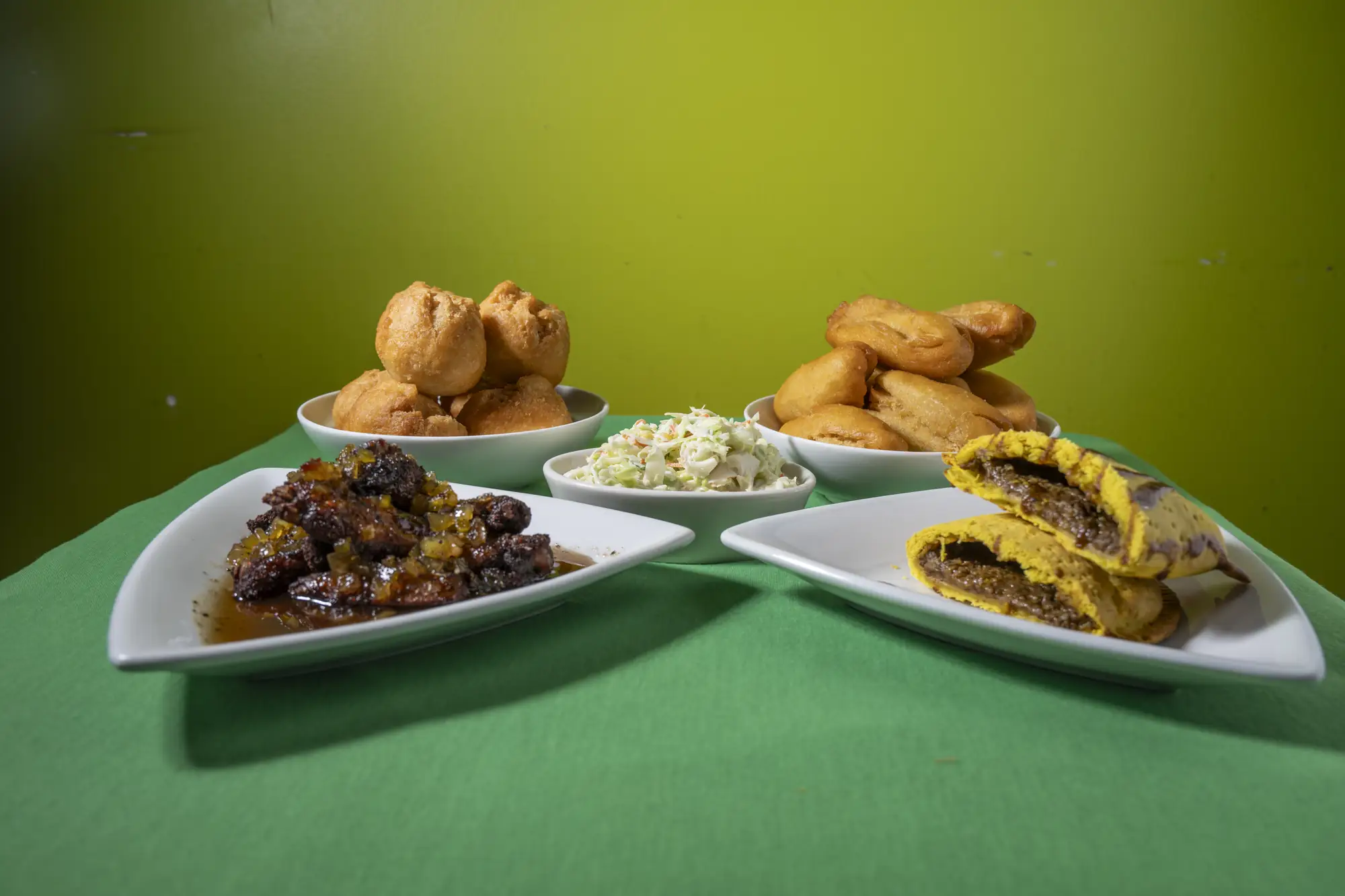Jerk chicken, beef patties and festival served family style at 11Hauz