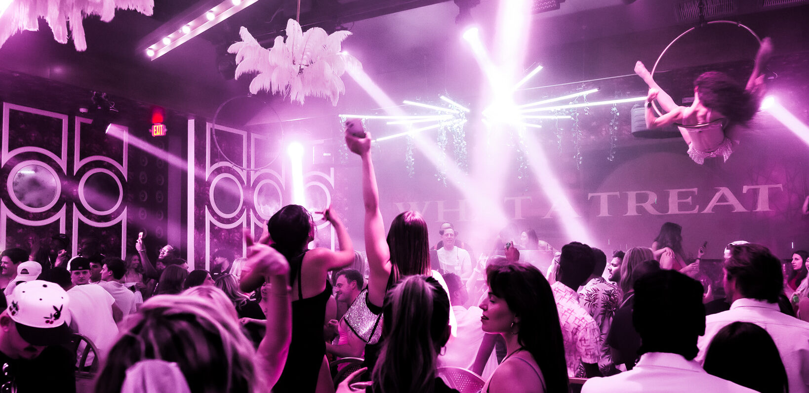 Crowd on the dance floor under pink lights at CAKE Nightclub
