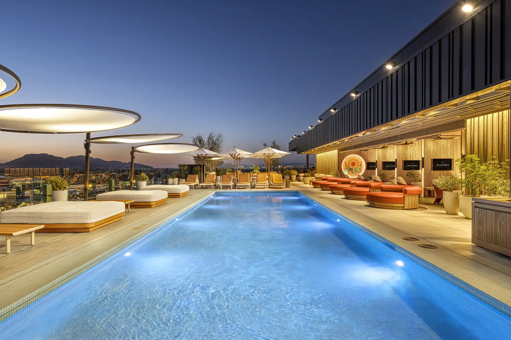 Allegra rooftop pool lit up at dusk