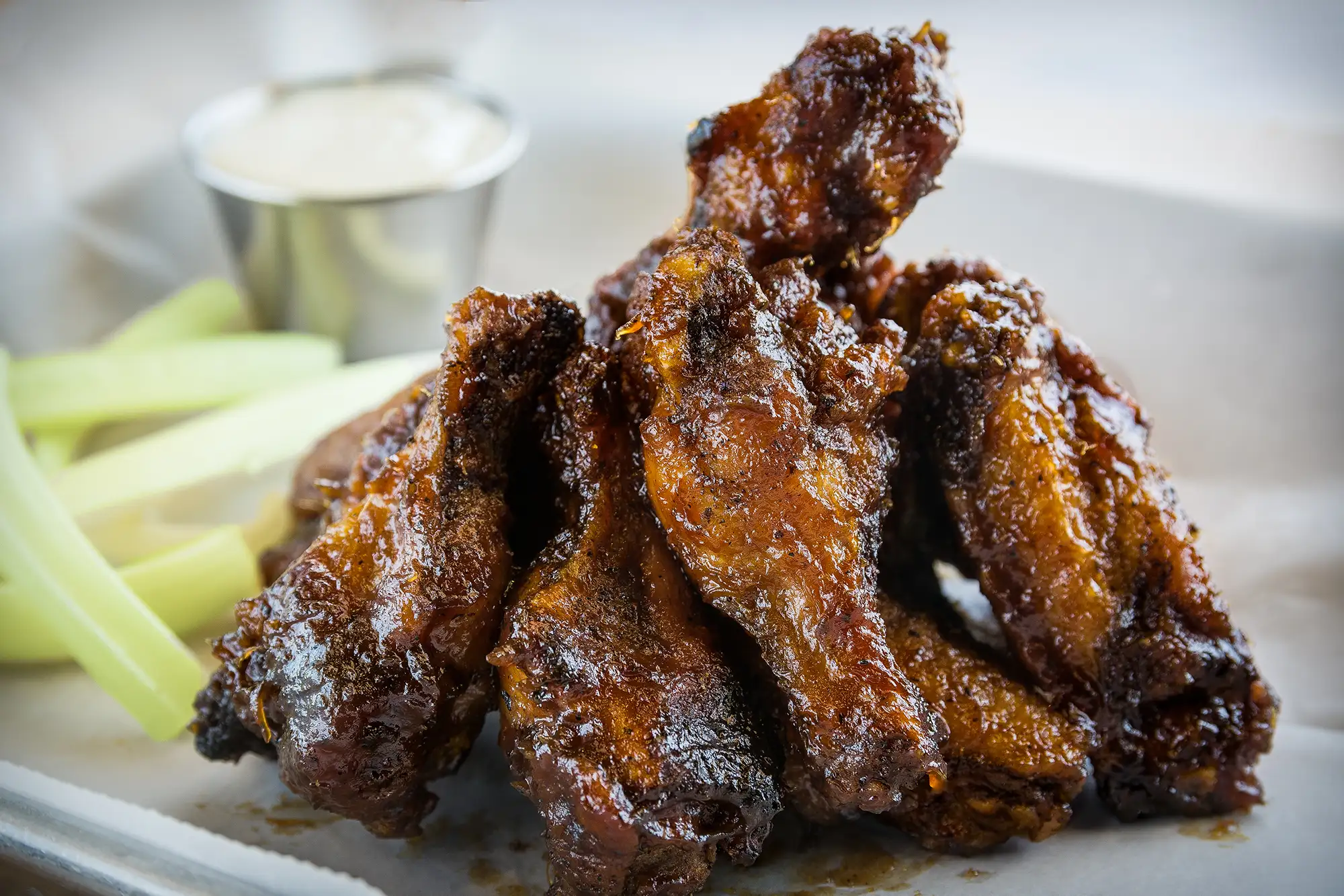 Glazed chicken wings with celery and dipping sauce at BRGR STOP