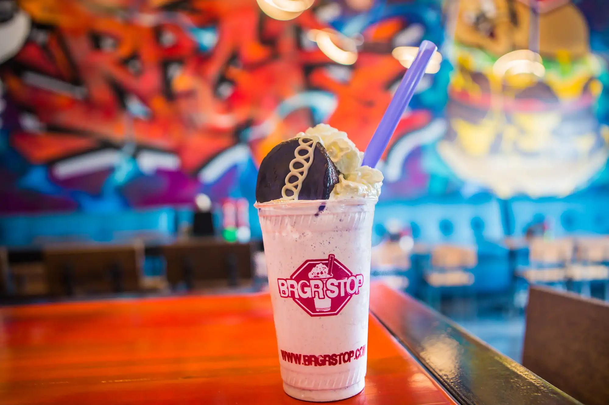 Milkshake topped with whipped cream and a cookie in a BRGR STOP cup