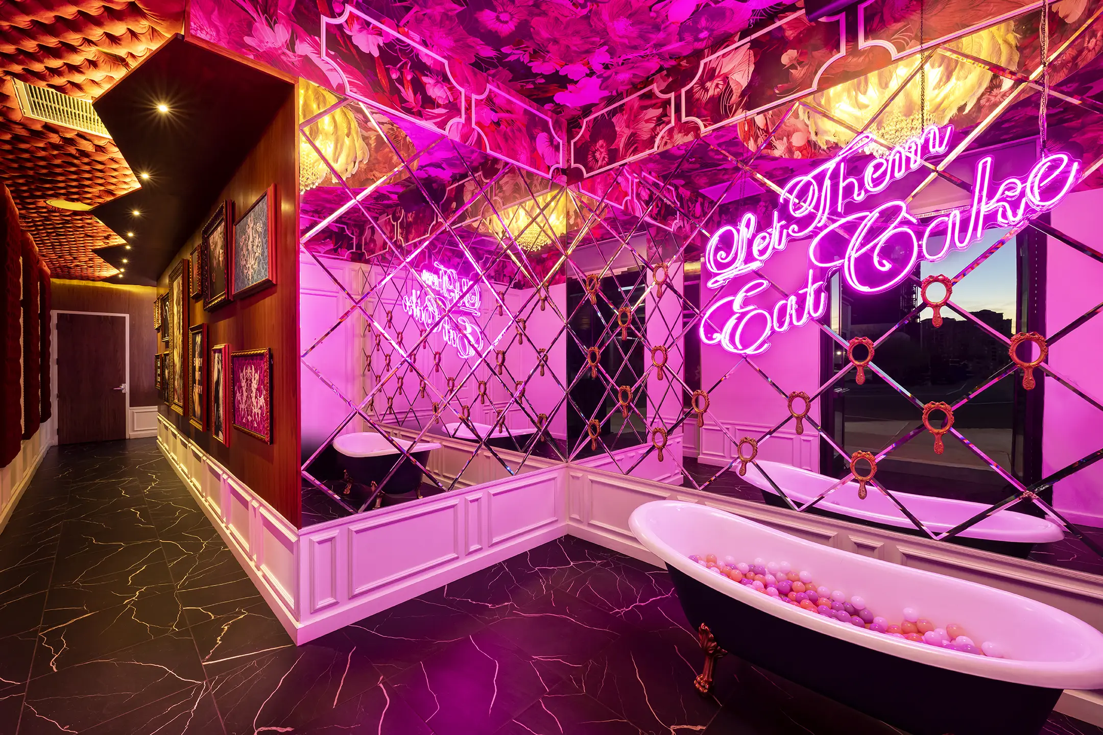 Pink room with a Let Them Eat Cake neon sign at CAKE Nightclub