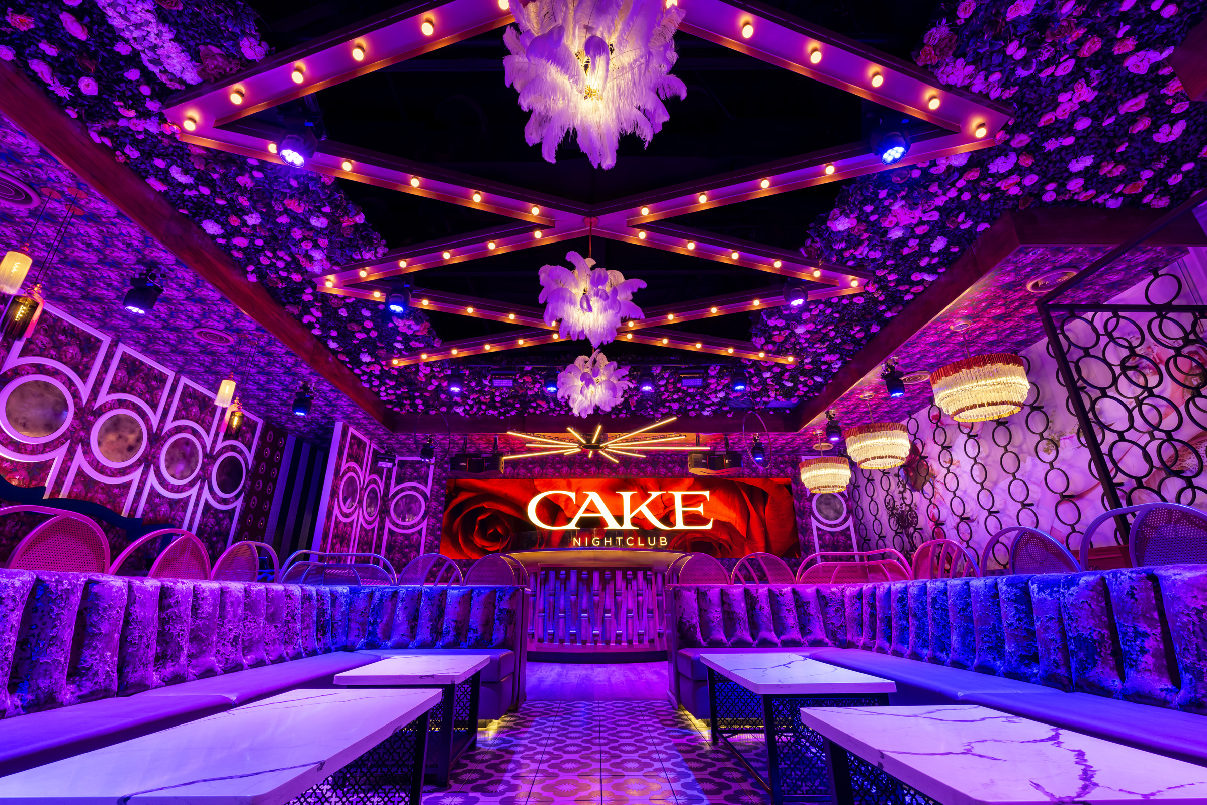 Main room at CAKE Nightclub with the CAKE sign above the booths