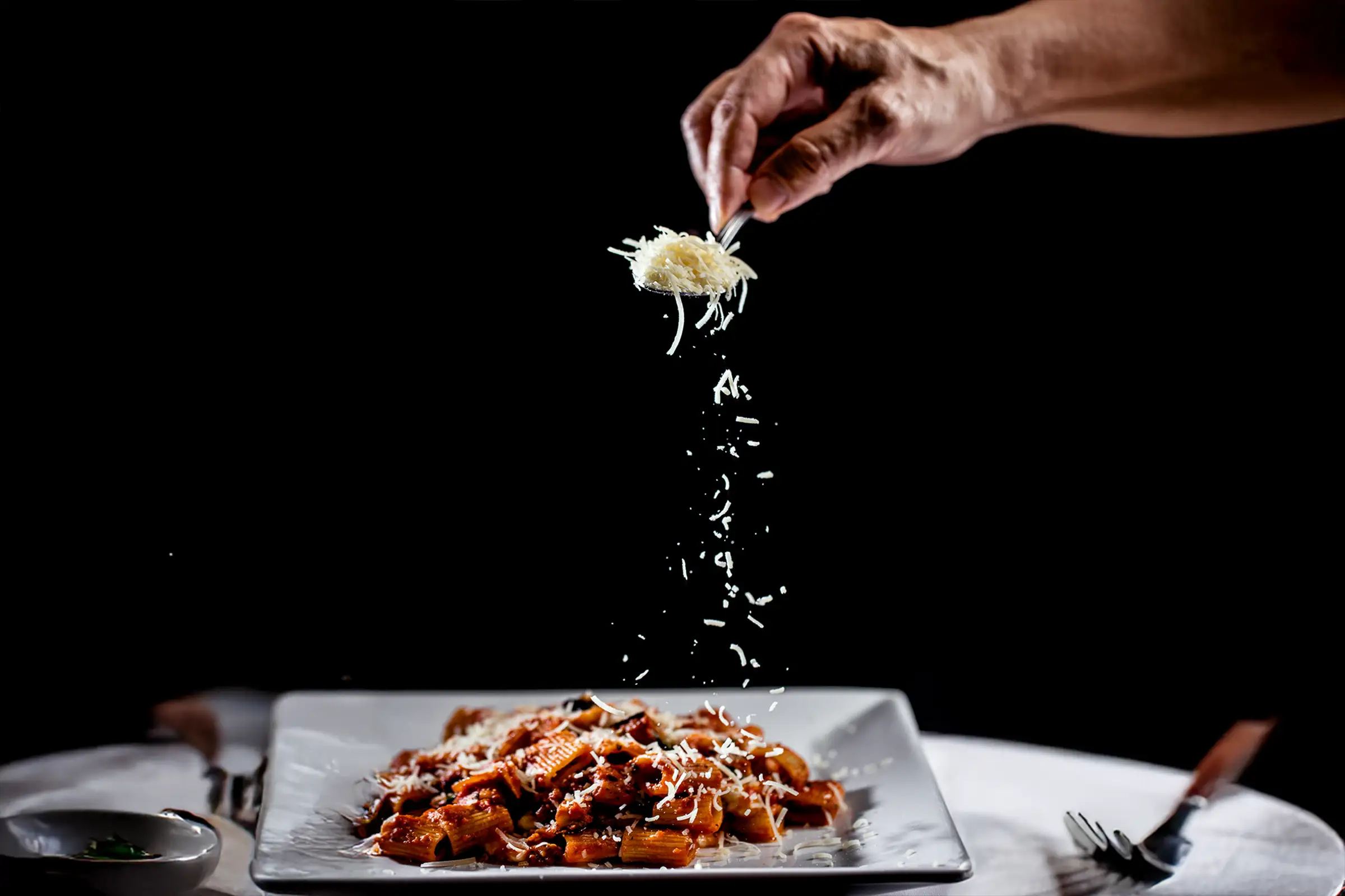 Cheese grated over a pasta dish at Capriccio Ristorante