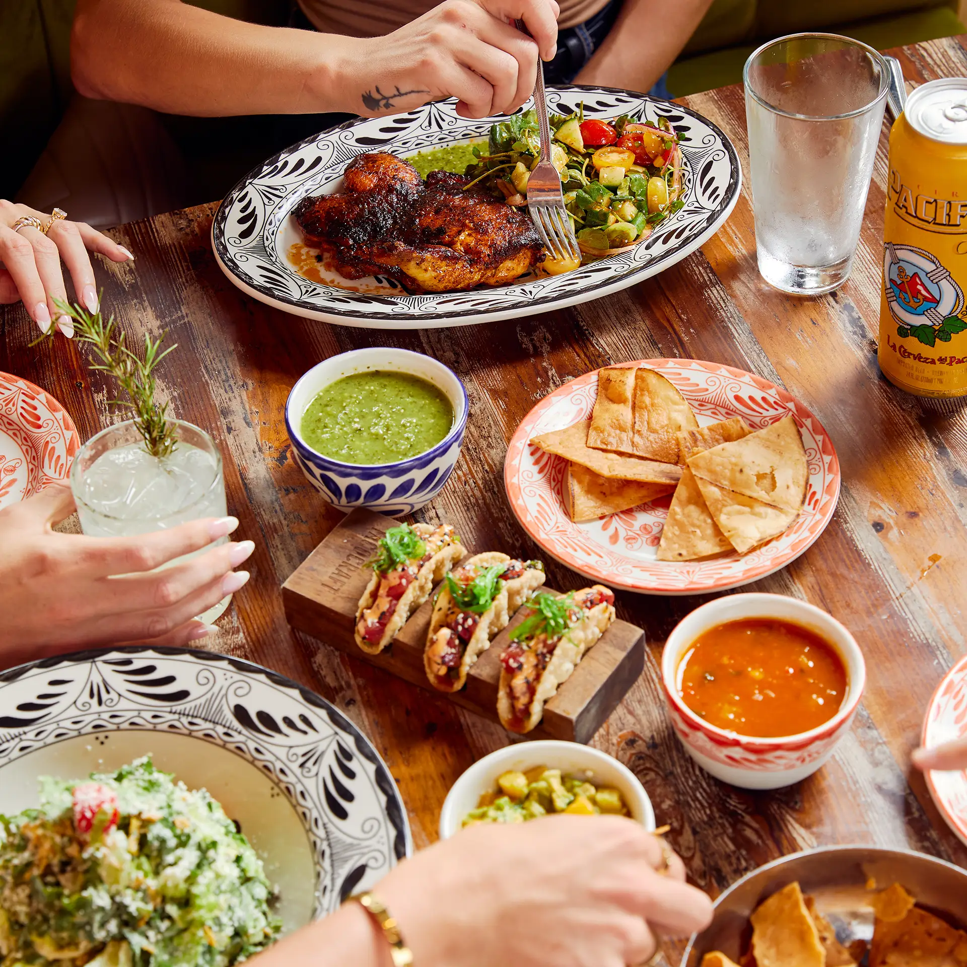 Friends sharing tacos, salsas and chips at Tacocraft