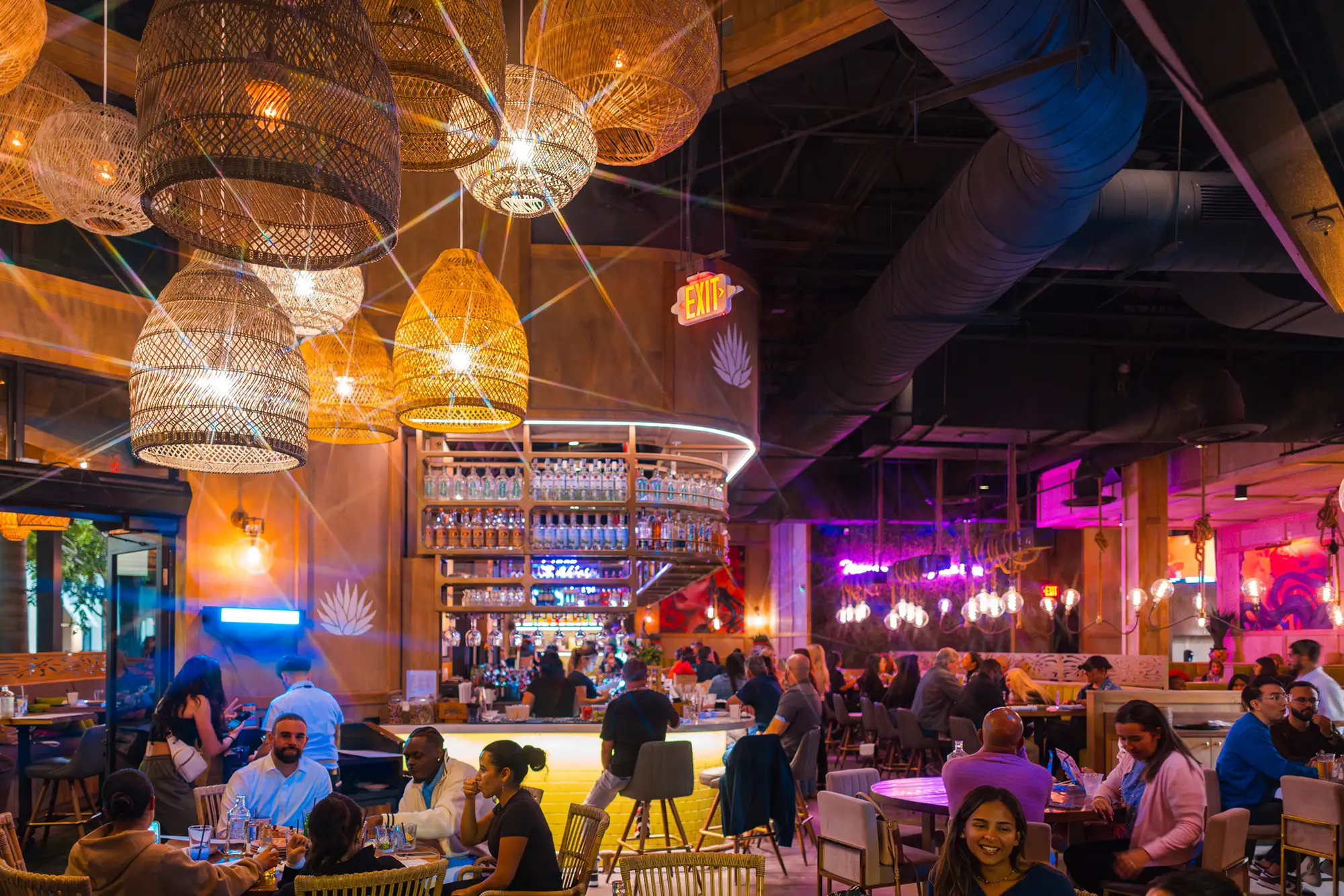 Busy Tacocraft dining room and bar under woven lantern lights