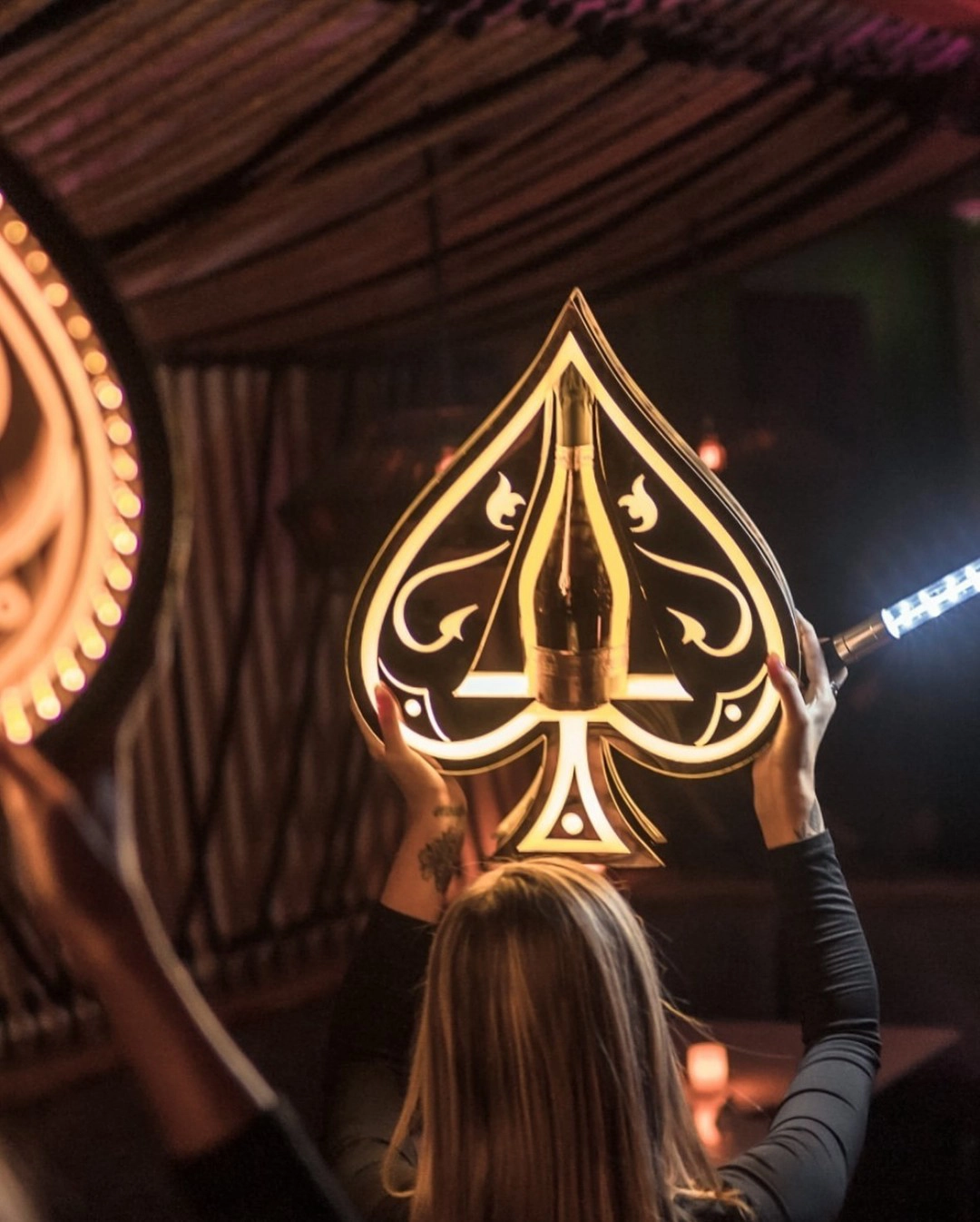Bottle service presentation with a lit spade sign at Cottontail Lounge