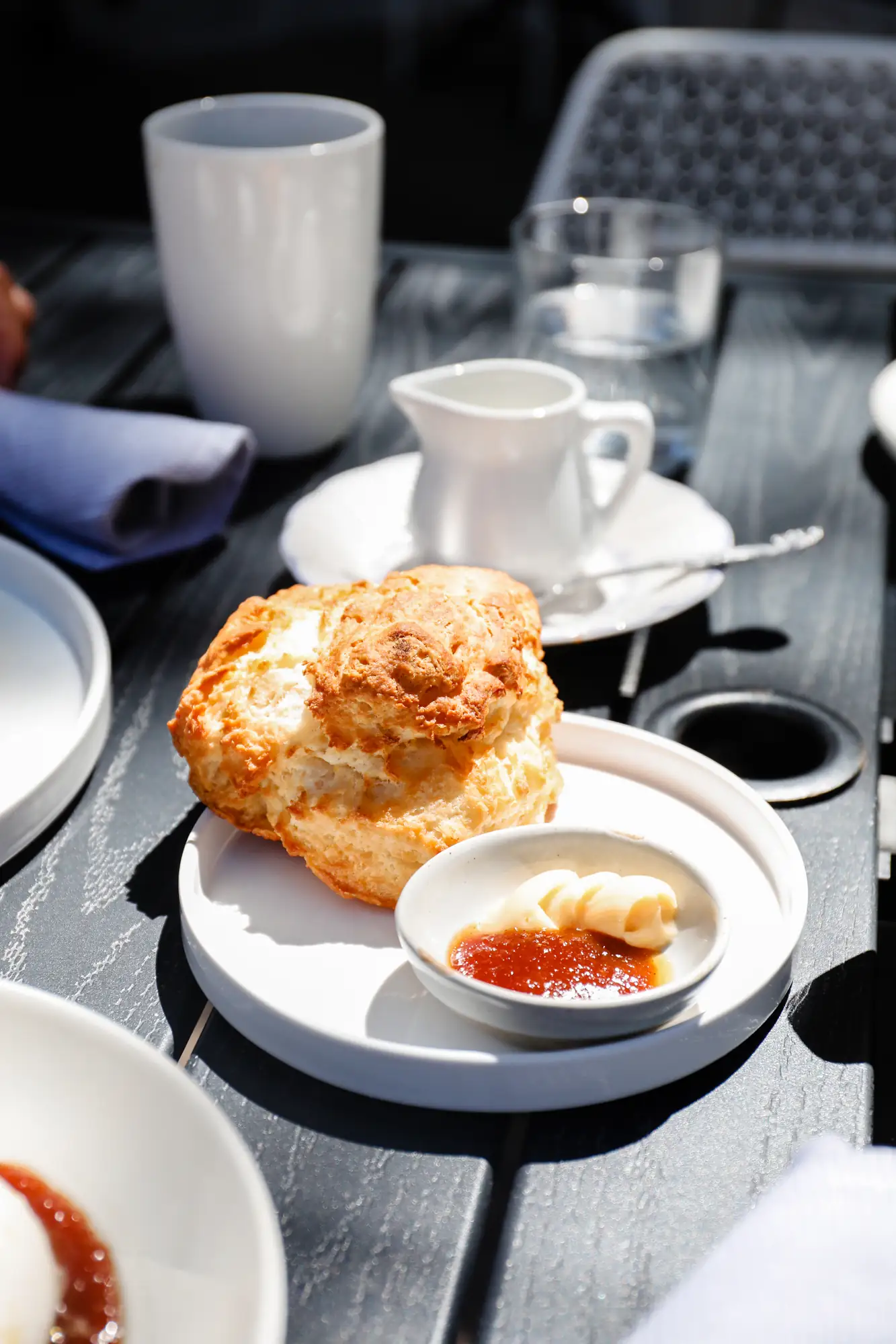 Buttermilk biscuit with butter and jam on the Scratchboard Kitchen patio