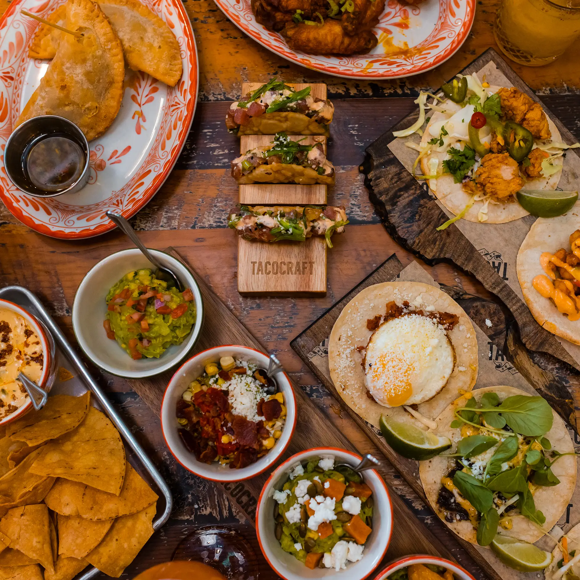 Overhead view of tacos, guacamole, chips and salsas at Tacocraft