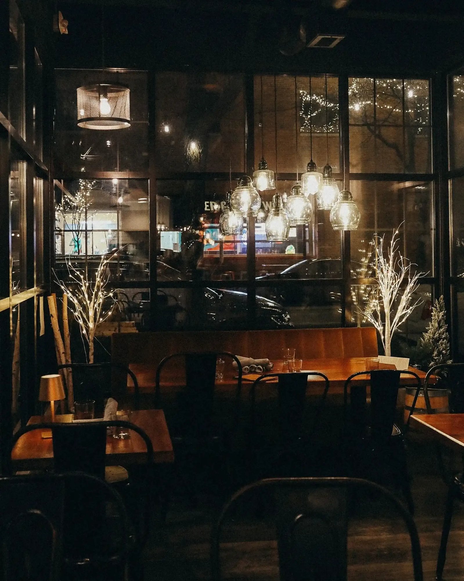 The Scratchboard Kitchen dining room at night under glowing pendant lights
